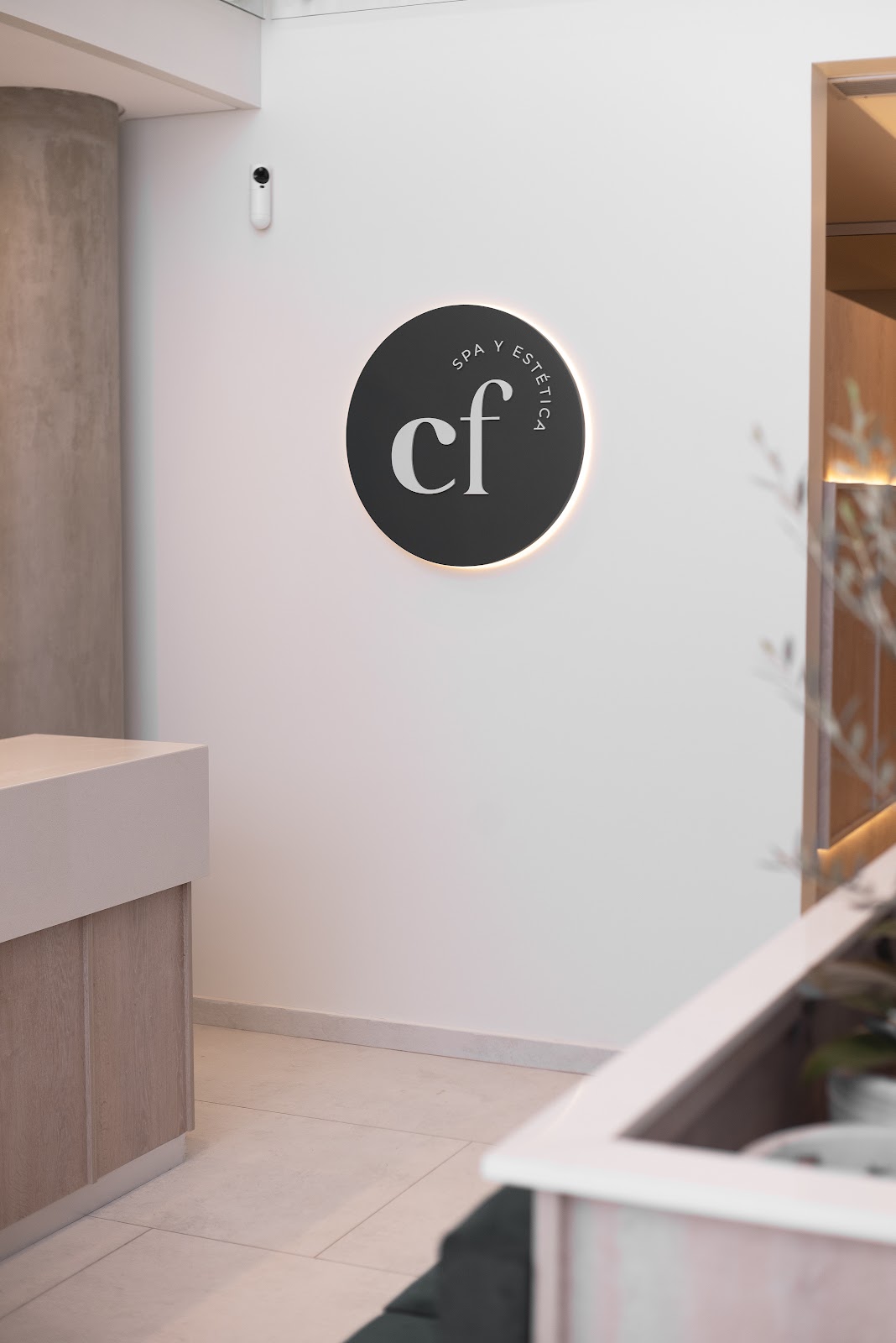 Recepción de CF Spa y Estética con su logo iluminado en la pared