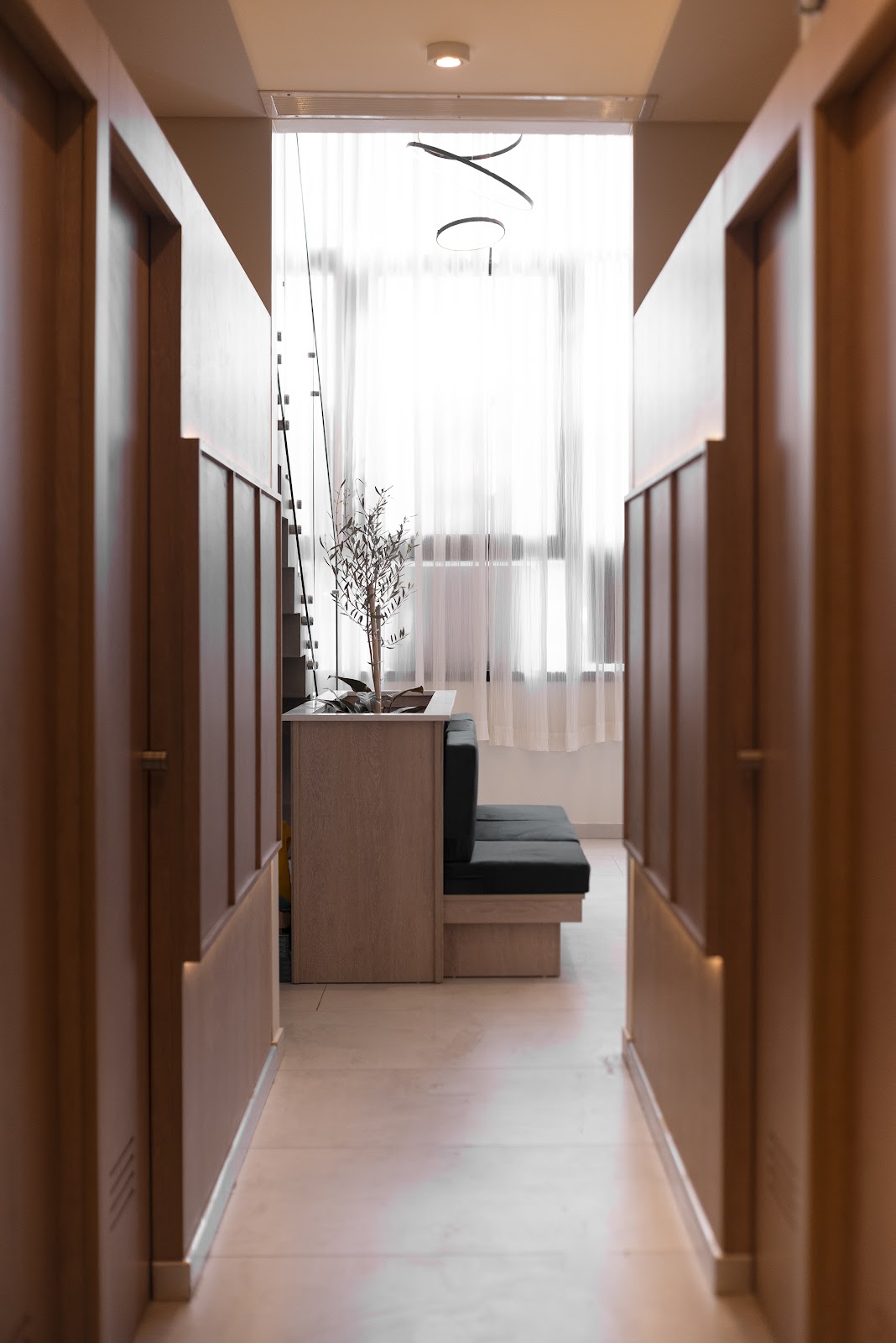 Pasillo de cabinas con puertas de madera y sala de espera al fondo